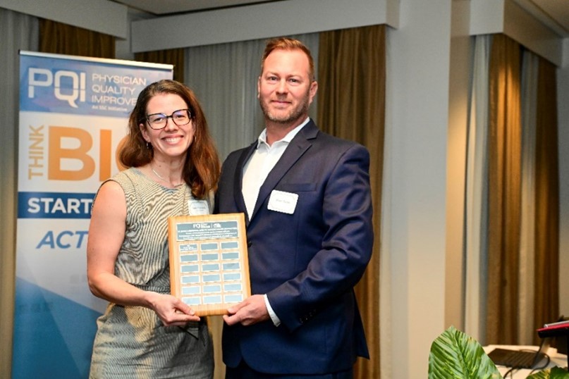 Dr. Sara Sandwith, receiving the award plaque from Sean Oates.jpg