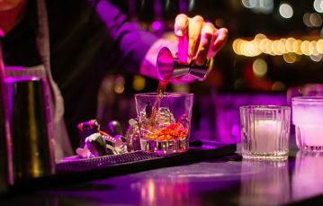 bartender pouring alcohol into a glass
