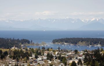 Panoramic skyline with coastal mountain range in back against Salish sea leading up to neighbourhood homes Nanaimo Vancouver Island BC Canada