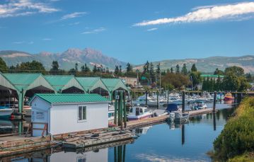 Marina on a quay with mountain backdrop and blue sky in Port Alberni Vancouver Island Canada